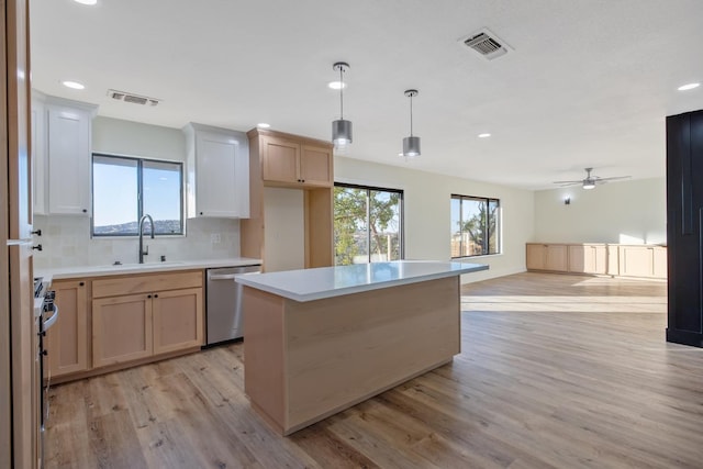 kitchen with a kitchen island, stainless steel appliances, backsplash, decorative light fixtures, and light wood-type flooring