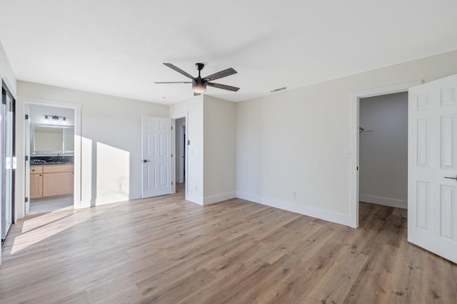 empty room with sink, light hardwood / wood-style floors, and ceiling fan