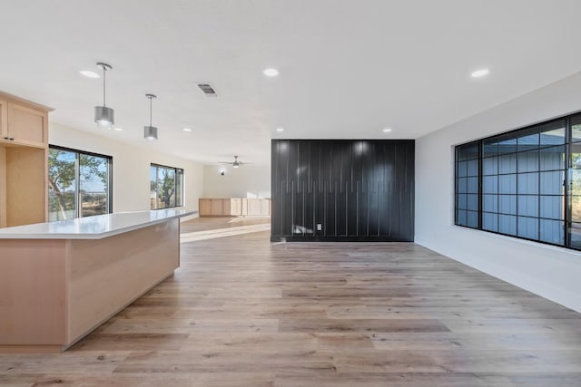 kitchen with light hardwood / wood-style floors, hanging light fixtures, a center island, and light brown cabinetry