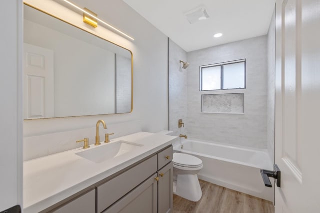 full bathroom with vanity, hardwood / wood-style floors, tiled shower / bath combo, and toilet