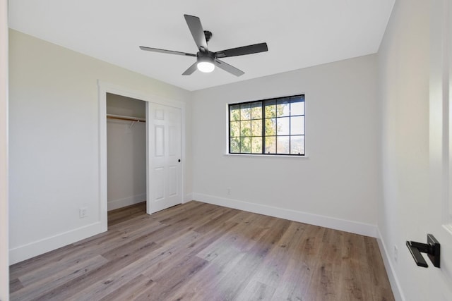 unfurnished bedroom with a closet, light wood-type flooring, and ceiling fan