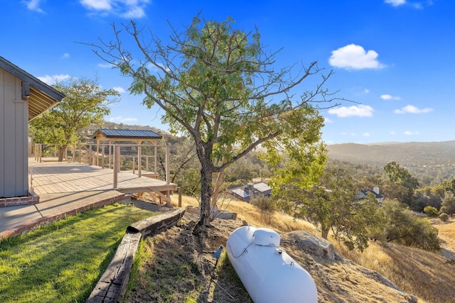 view of yard with a deck with mountain view