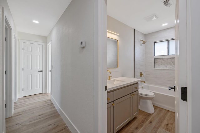 full bathroom with toilet, tiled shower / bath, vanity, and wood-type flooring