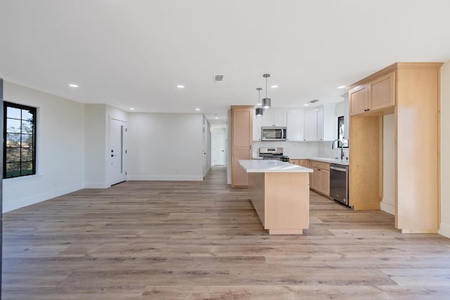 kitchen featuring a center island, stainless steel appliances, and light hardwood / wood-style floors