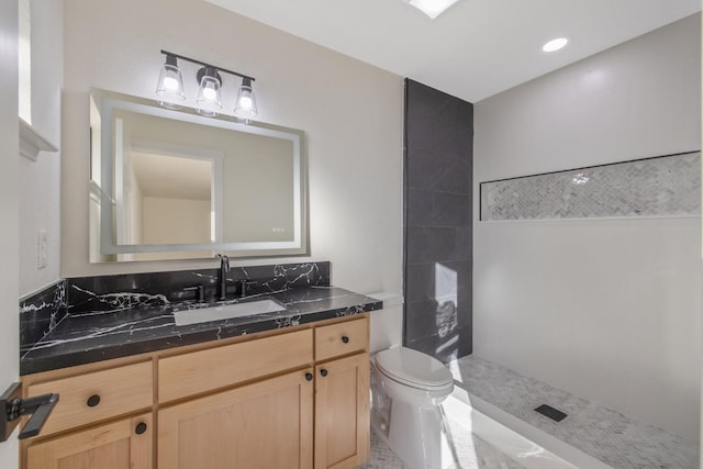 bathroom featuring vanity, toilet, and tiled shower