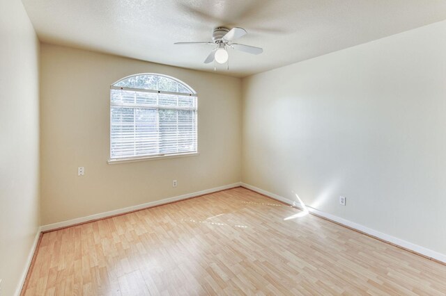 spare room featuring a textured ceiling, light wood-type flooring, and ceiling fan