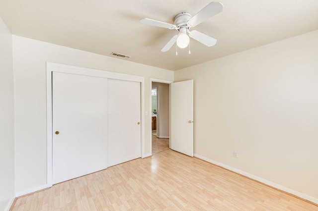 unfurnished bedroom featuring a closet, light wood-type flooring, and ceiling fan