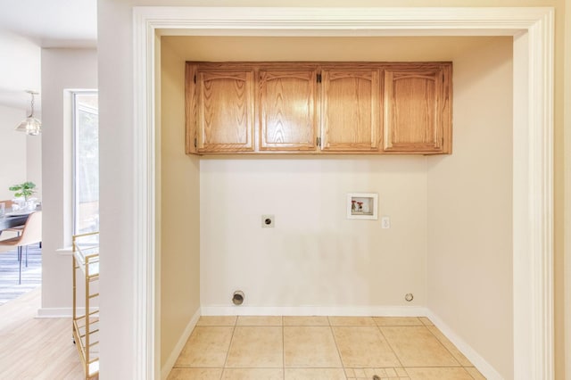 clothes washing area featuring cabinets, hookup for an electric dryer, a healthy amount of sunlight, and washer hookup