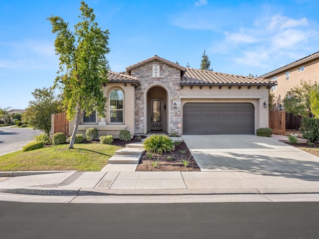 mediterranean / spanish-style home featuring a garage and a front lawn