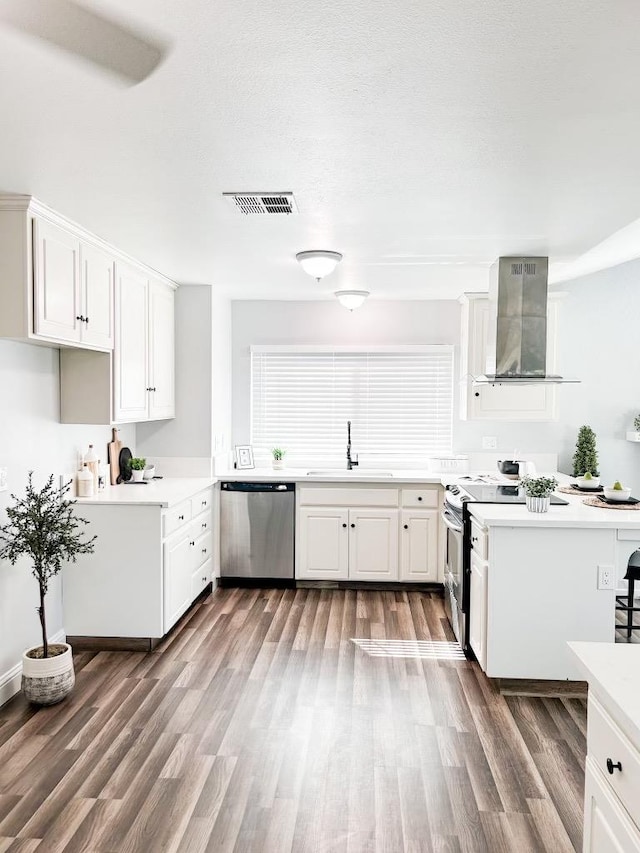 kitchen with dishwasher, white cabinets, dark wood-type flooring, and wall chimney range hood