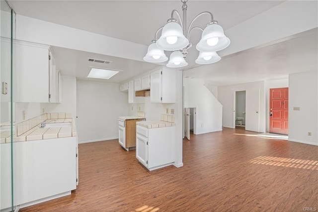 49400 River Park Rd Unit 17, Oakhurst, CA 93644 - kitchen featuring tile countertops, wood finished floors, and white cabinets