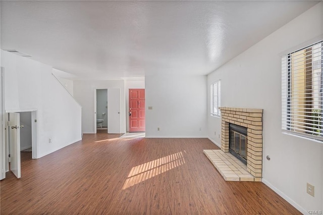 49400 River Park Rd Unit 17, Oakhurst, CA 93644 - unfurnished living room featuring wood finished floors, a fireplace, and baseboards
