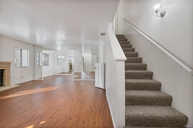 49400 River Park Rd Unit 17, Oakhurst, CA 93644 - stairs featuring wood finished floors, a fireplace, and baseboards