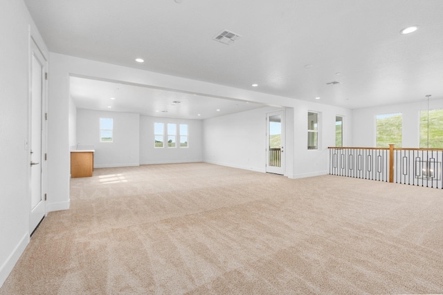 unfurnished room with light carpet and plenty of natural light