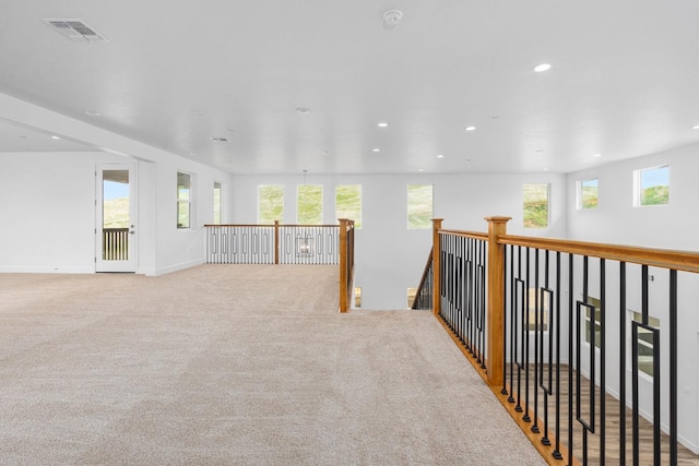 unfurnished room featuring plenty of natural light and light colored carpet