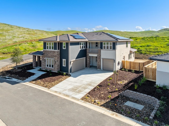 view of front of house with a garage, a mountain view, and solar panels