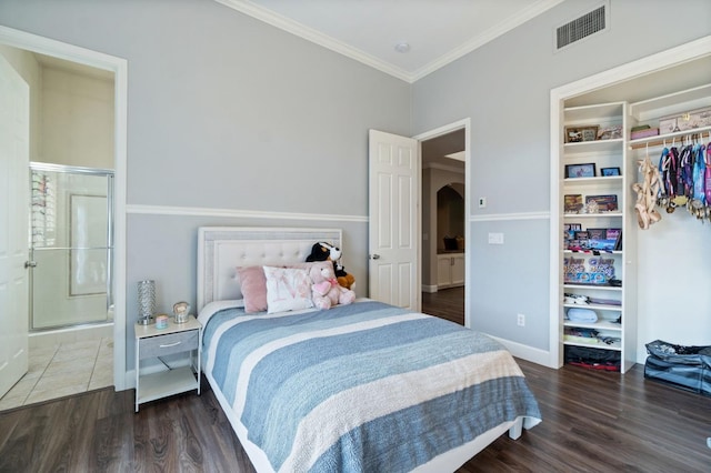 bedroom featuring ornamental molding, dark wood-type flooring, and a closet