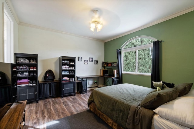 bedroom with hardwood / wood-style flooring, ceiling fan, and ornamental molding