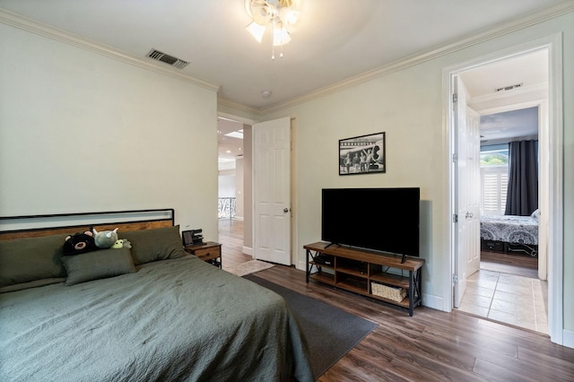 bedroom featuring ceiling fan, hardwood / wood-style flooring, and crown molding