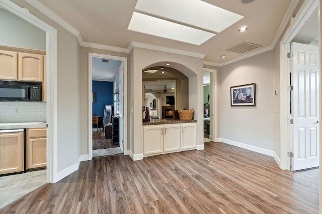 kitchen with ceiling fan, ornamental molding, backsplash, and light hardwood / wood-style flooring