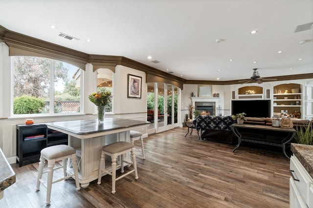 dining area featuring ornamental molding, ceiling fan, and dark wood-type flooring