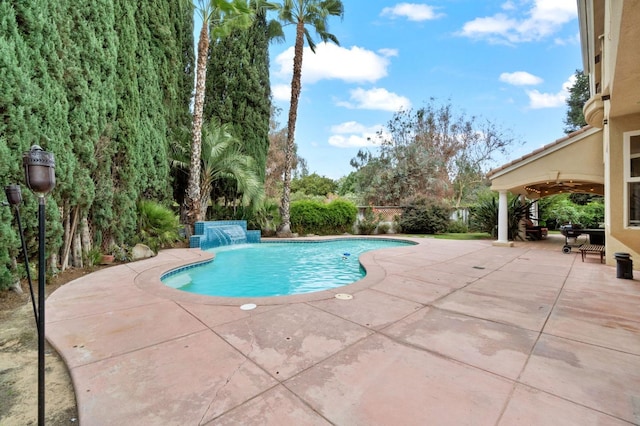 view of swimming pool with pool water feature and a patio area