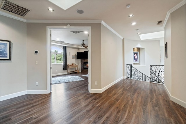 interior space with ornamental molding, dark hardwood / wood-style flooring, a skylight, and ceiling fan