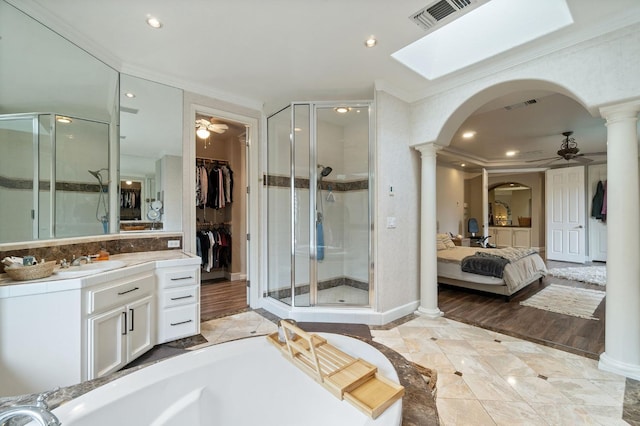 bathroom with ornate columns, ceiling fan, a shower with shower door, and crown molding