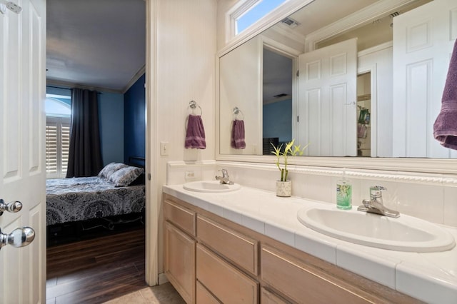 bathroom featuring vanity, hardwood / wood-style flooring, and crown molding