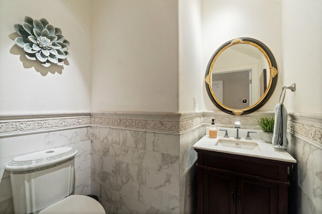 bathroom with toilet, tile walls, and vanity