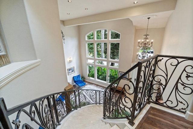 stairway featuring wood-type flooring and a chandelier