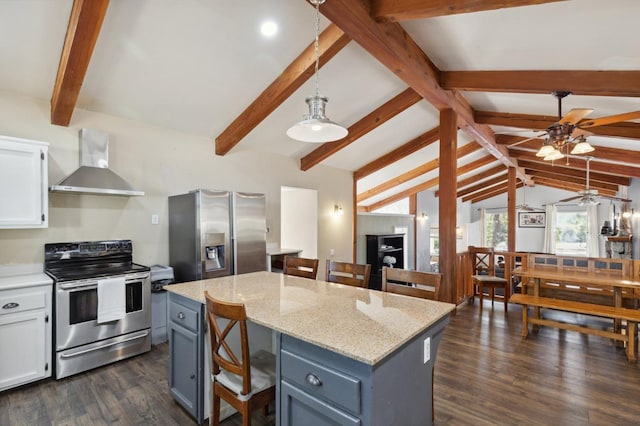 kitchen featuring white cabinetry, wall chimney exhaust hood, appliances with stainless steel finishes, and a center island