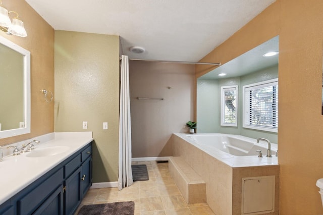 bathroom with vanity, tiled tub, and tile patterned floors