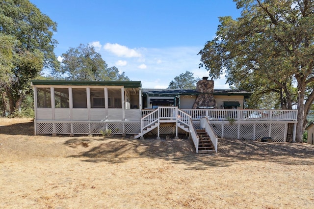 rear view of house with a wooden deck and a sunroom