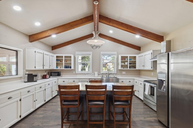 kitchen with a kitchen island, appliances with stainless steel finishes, white cabinets, and dark hardwood / wood-style flooring