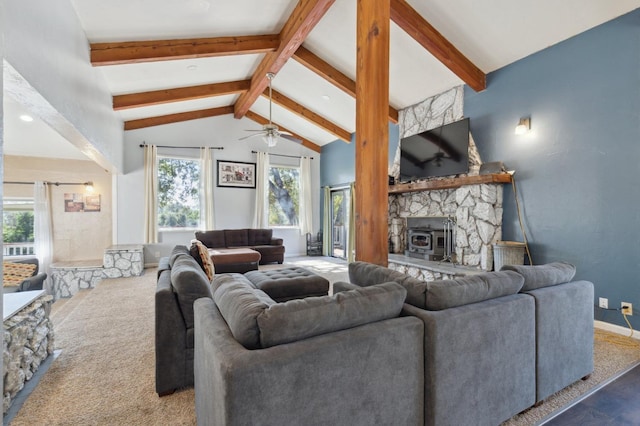 living room featuring ceiling fan, high vaulted ceiling, a wood stove, and beamed ceiling