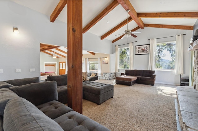 carpeted living room with ceiling fan, lofted ceiling with beams, and a fireplace