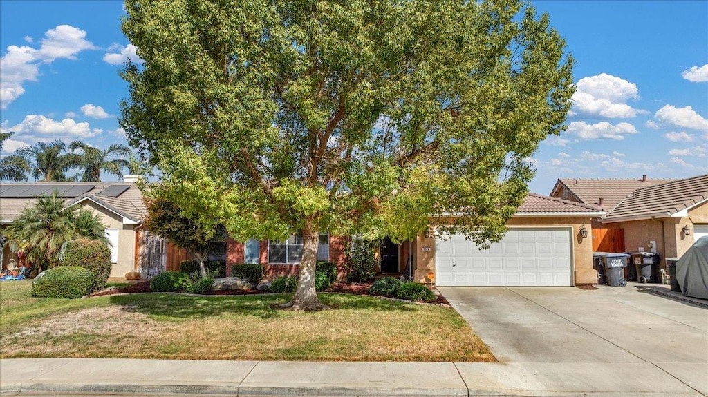 obstructed view of property featuring a garage and a front lawn