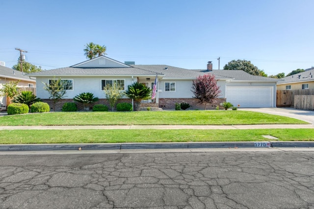 ranch-style house featuring a garage and a front lawn