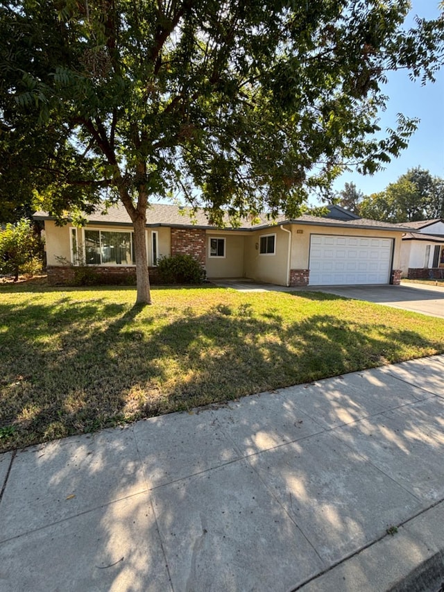 single story home featuring a front lawn and a garage