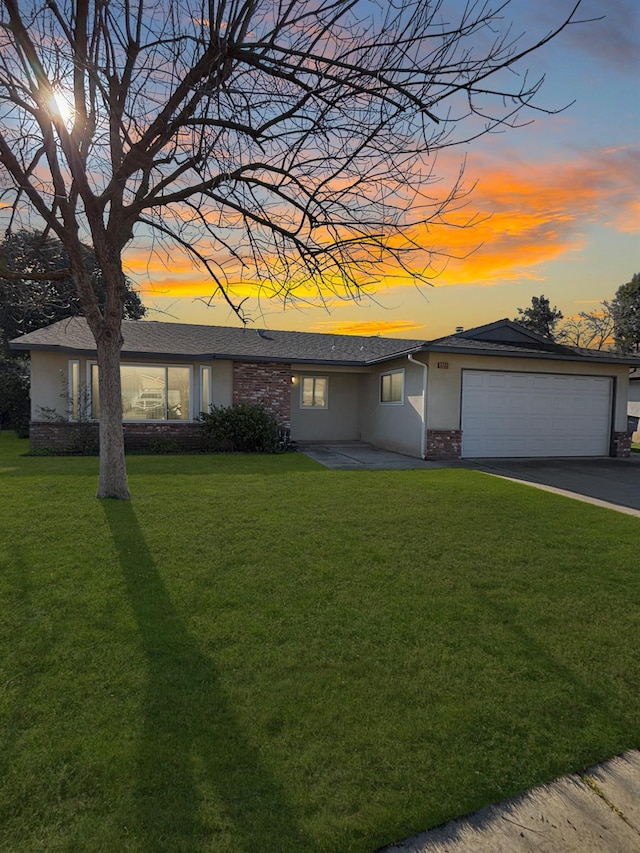 view of front of property with a yard and a garage