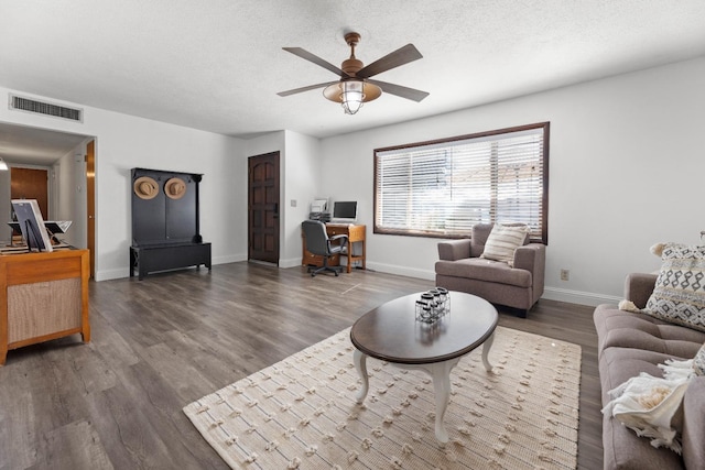 living room with a textured ceiling, dark wood-type flooring, and ceiling fan