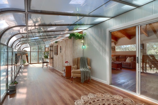 unfurnished sunroom with wood ceiling, plenty of natural light, and beamed ceiling