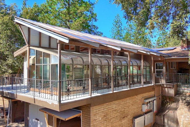 rear view of property featuring solar panels