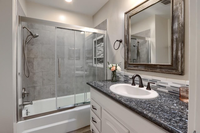 bathroom featuring enclosed tub / shower combo, vanity, and backsplash