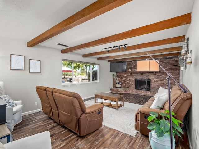 living area featuring dark wood finished floors, baseboards, visible vents, and a brick fireplace