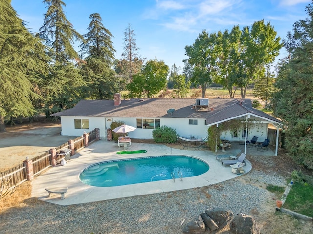 view of pool with a patio area, a fenced in pool, a fenced backyard, cooling unit, and french doors