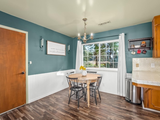dining area featuring visible vents, wainscoting, a chandelier, and dark wood-type flooring