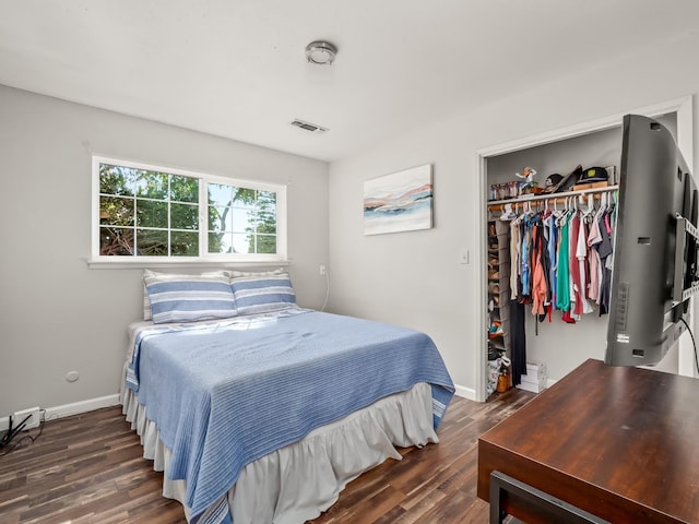 bedroom featuring wood finished floors, visible vents, a closet, and baseboards