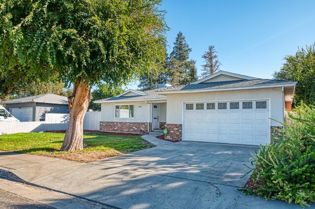 ranch-style house featuring a garage and a front lawn